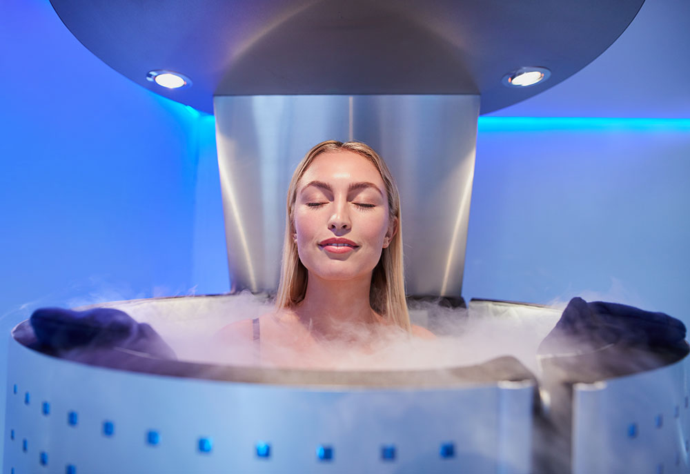 Young woman in a whole body cryotherapy cabin