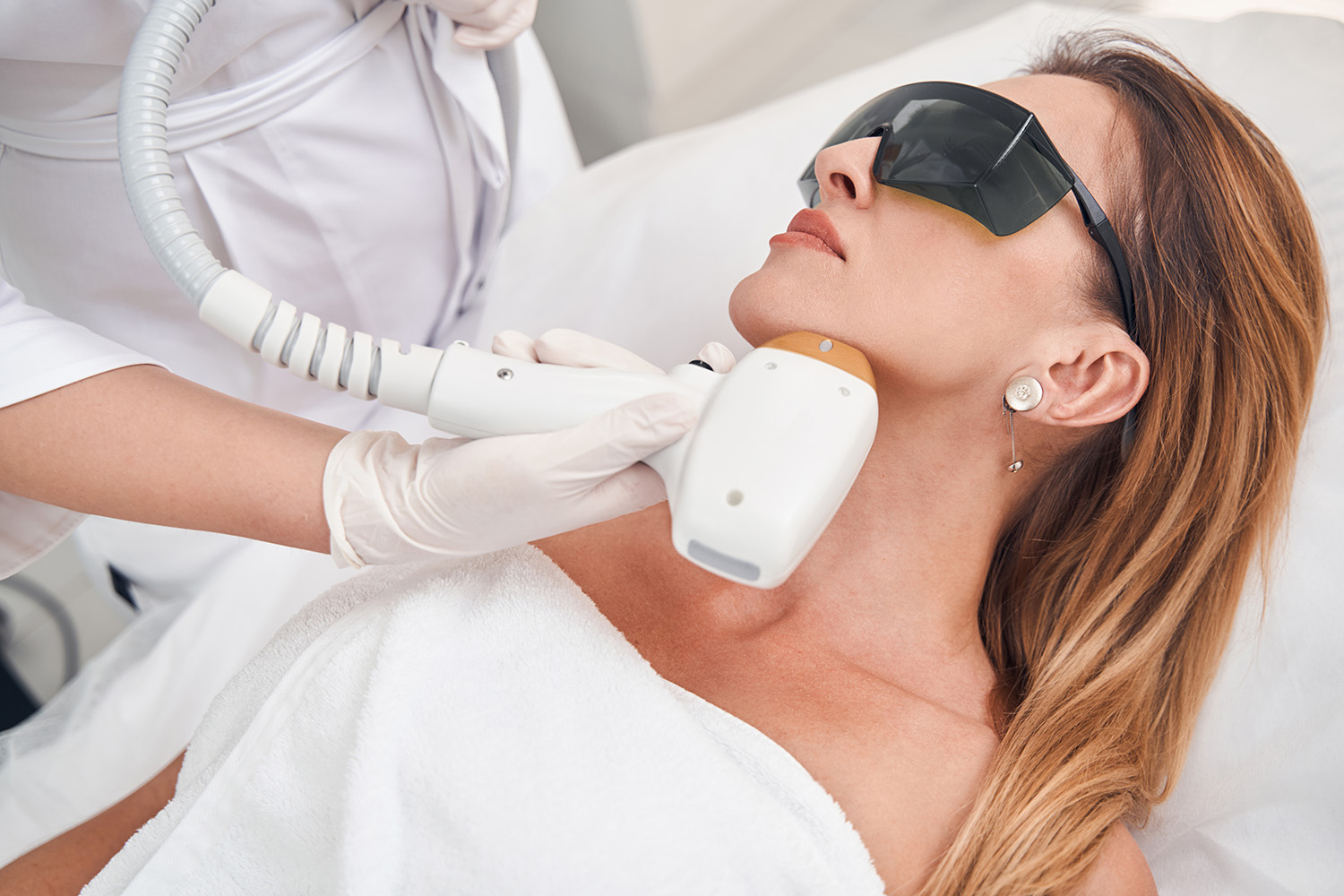 Calm female during laser treatment with professional