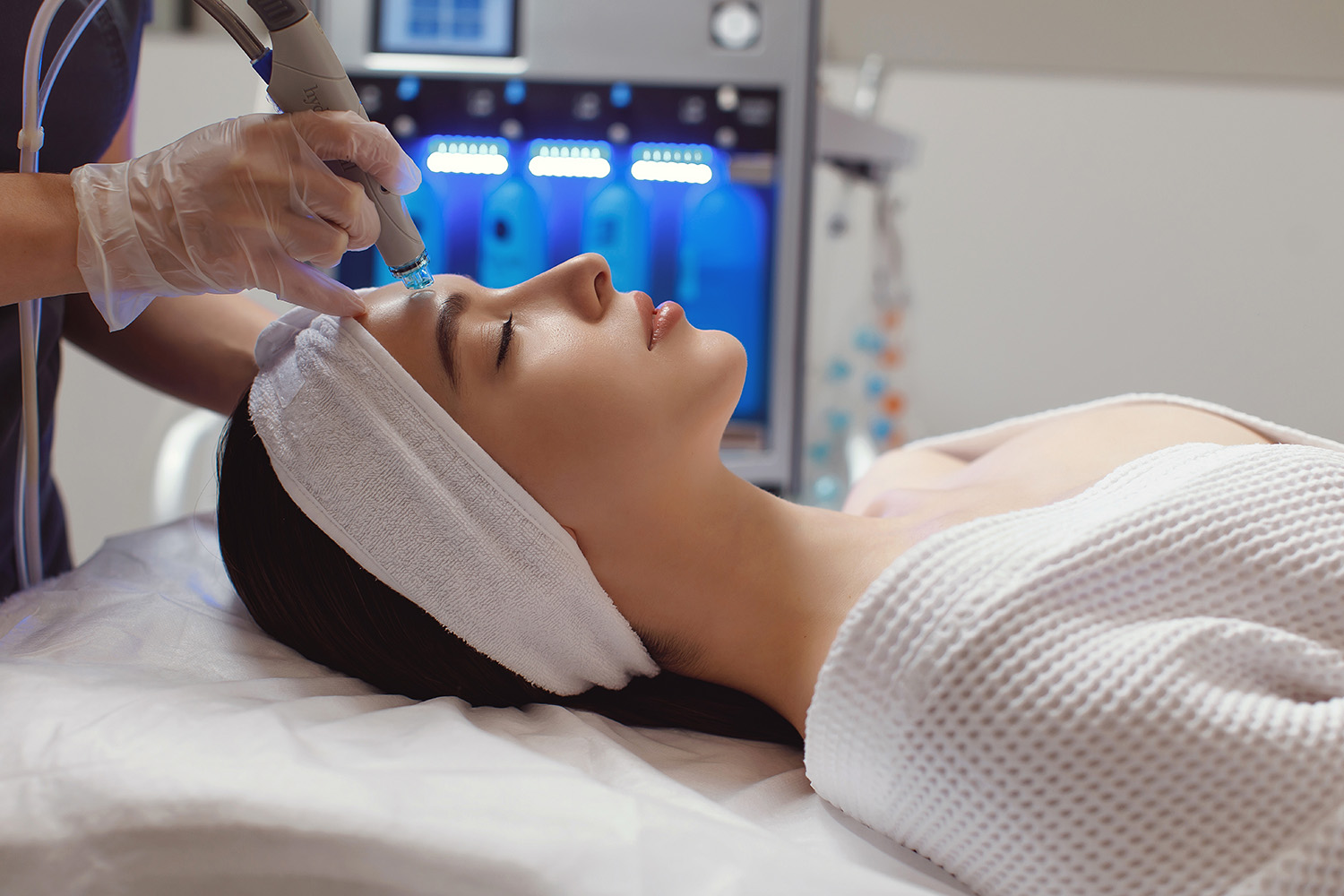 Side view of woman receiving microdermabrasion therapy on forehead
