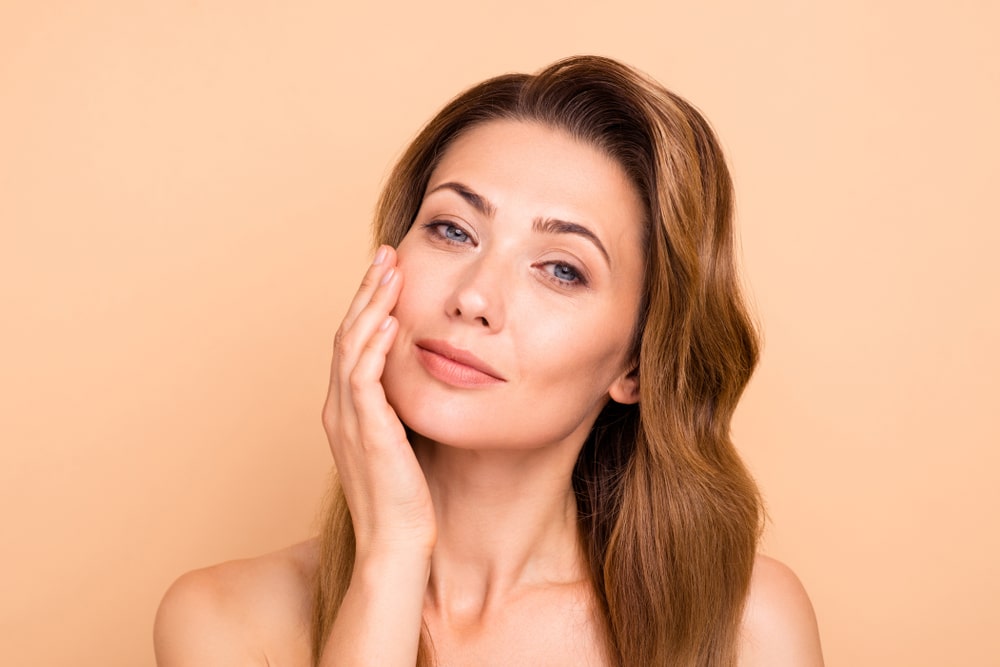 A woman gently touching her face after an UltraClear Laser session.