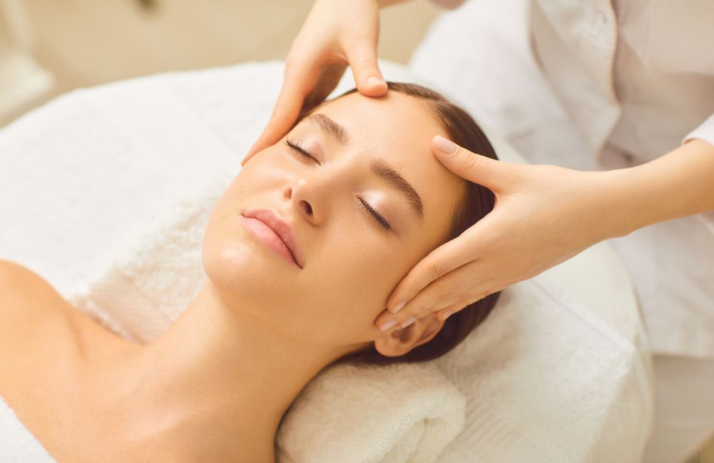 A woman receiving a relaxing Diamond Glow facial treatment.