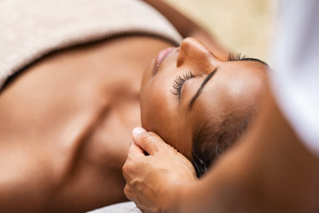 A relaxing facials session with a professional therapist gently massaging a woman's face.