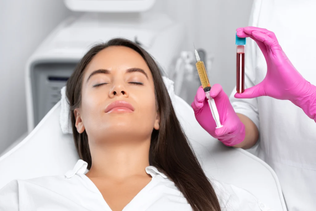 A skincare professional holding a PRP injection and a blood sample before a facial rejuvenation procedure.