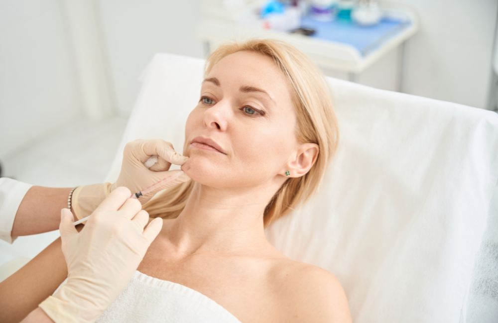 chin_filler_session Side-by-side comparison of a woman's neck before and after platysmal band injections.
